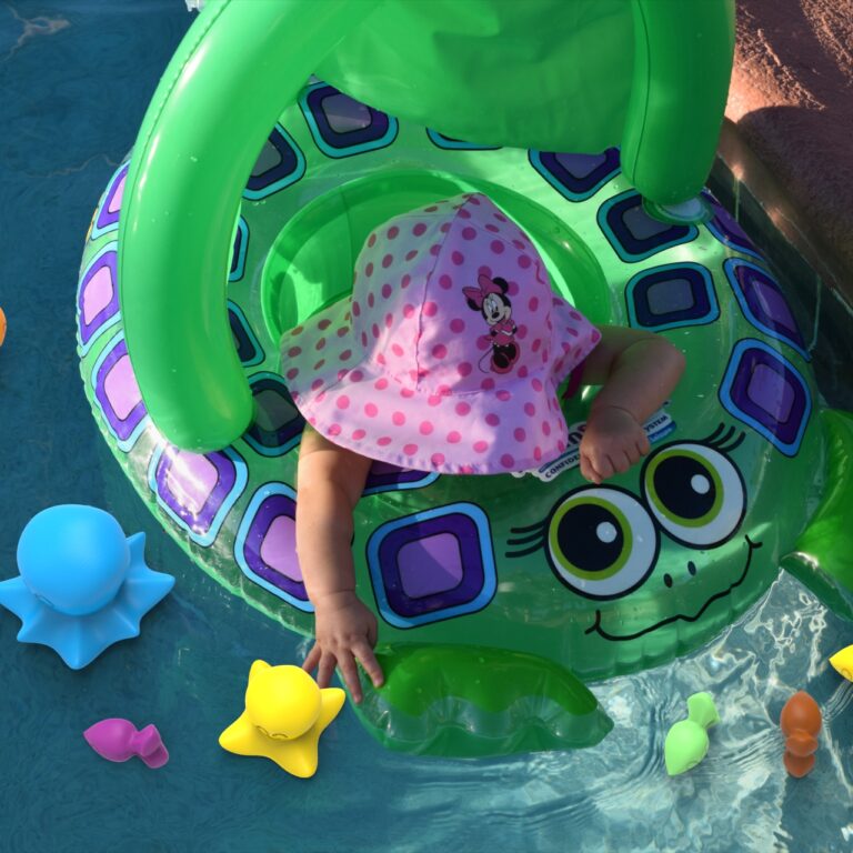 Toddler playing with Koa's Fishing Adventure while sitting in a pool ring.  