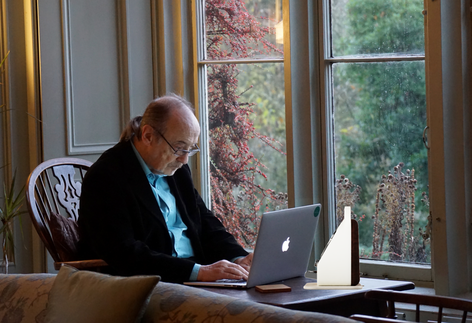Elderly man with early onset dementia on a laptop with their connect device nearby.